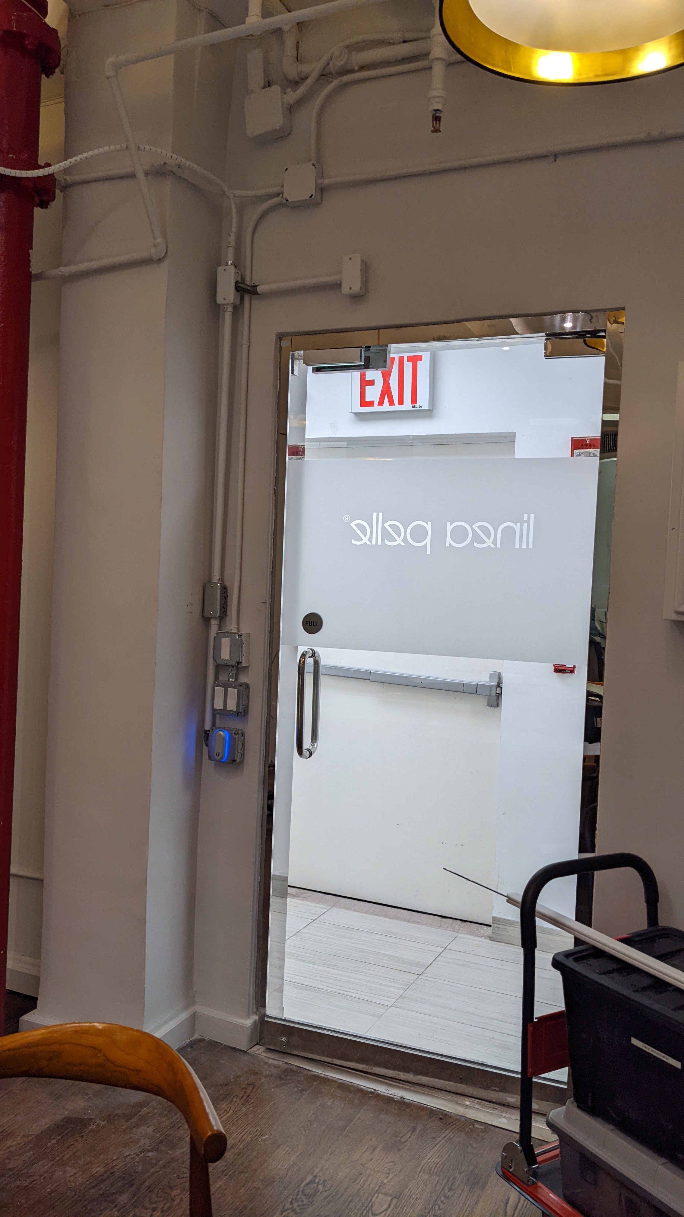 Door access reader with call button beside a glass office entrance