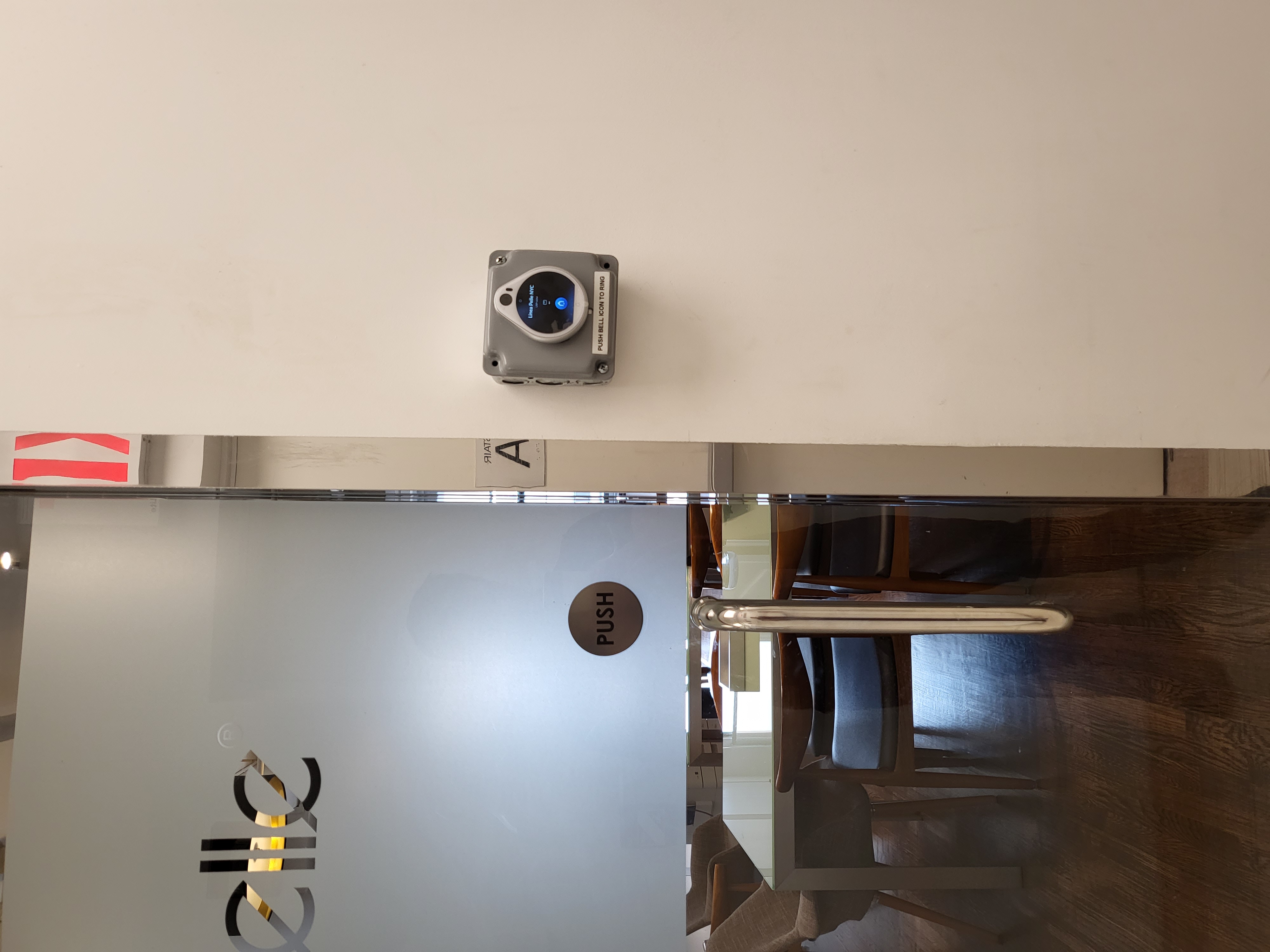 Wireless intercom and access control unit mounted beside an office door