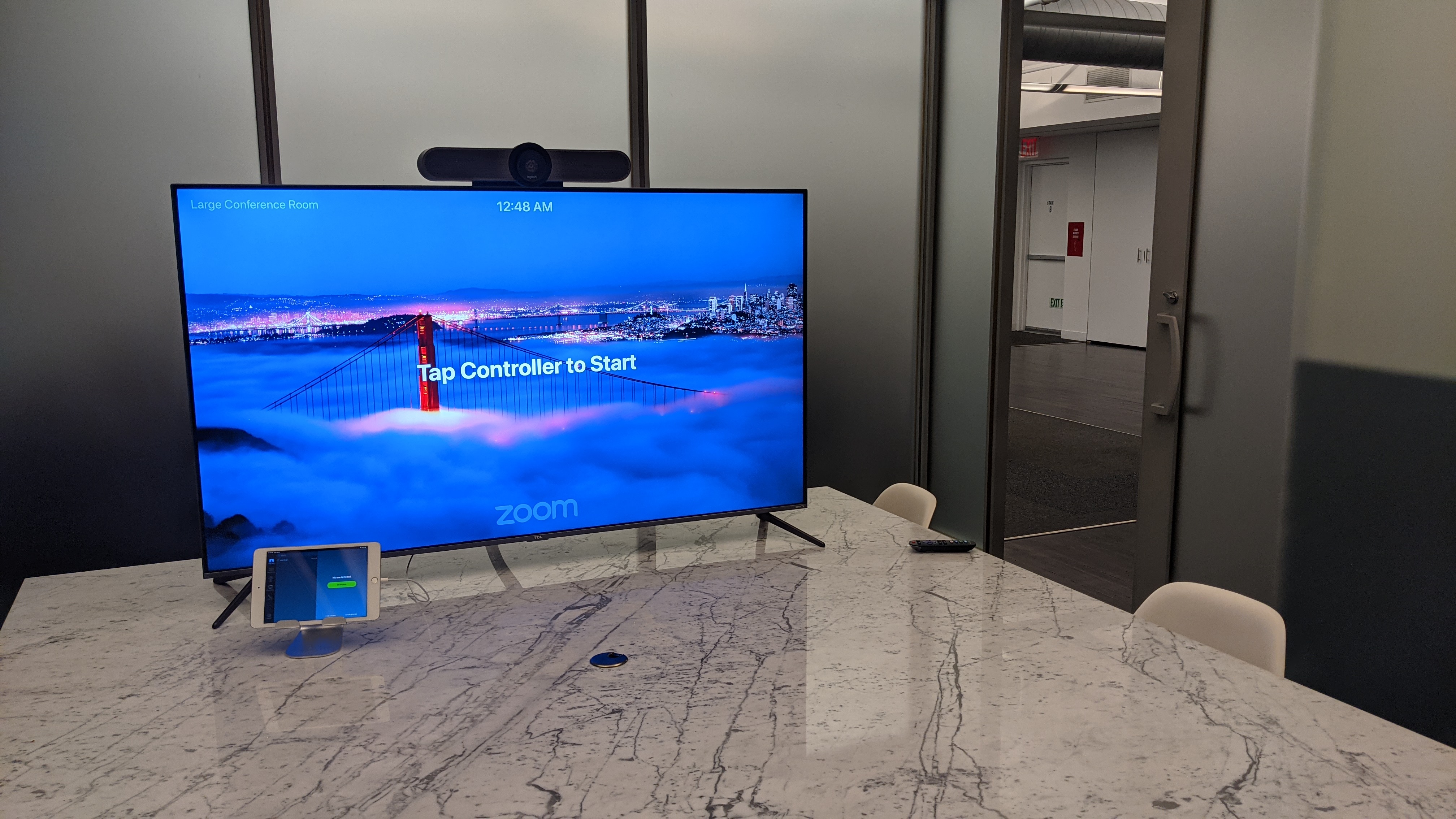 Conference room TV with Zoom Rooms controller ready to start a meeting
