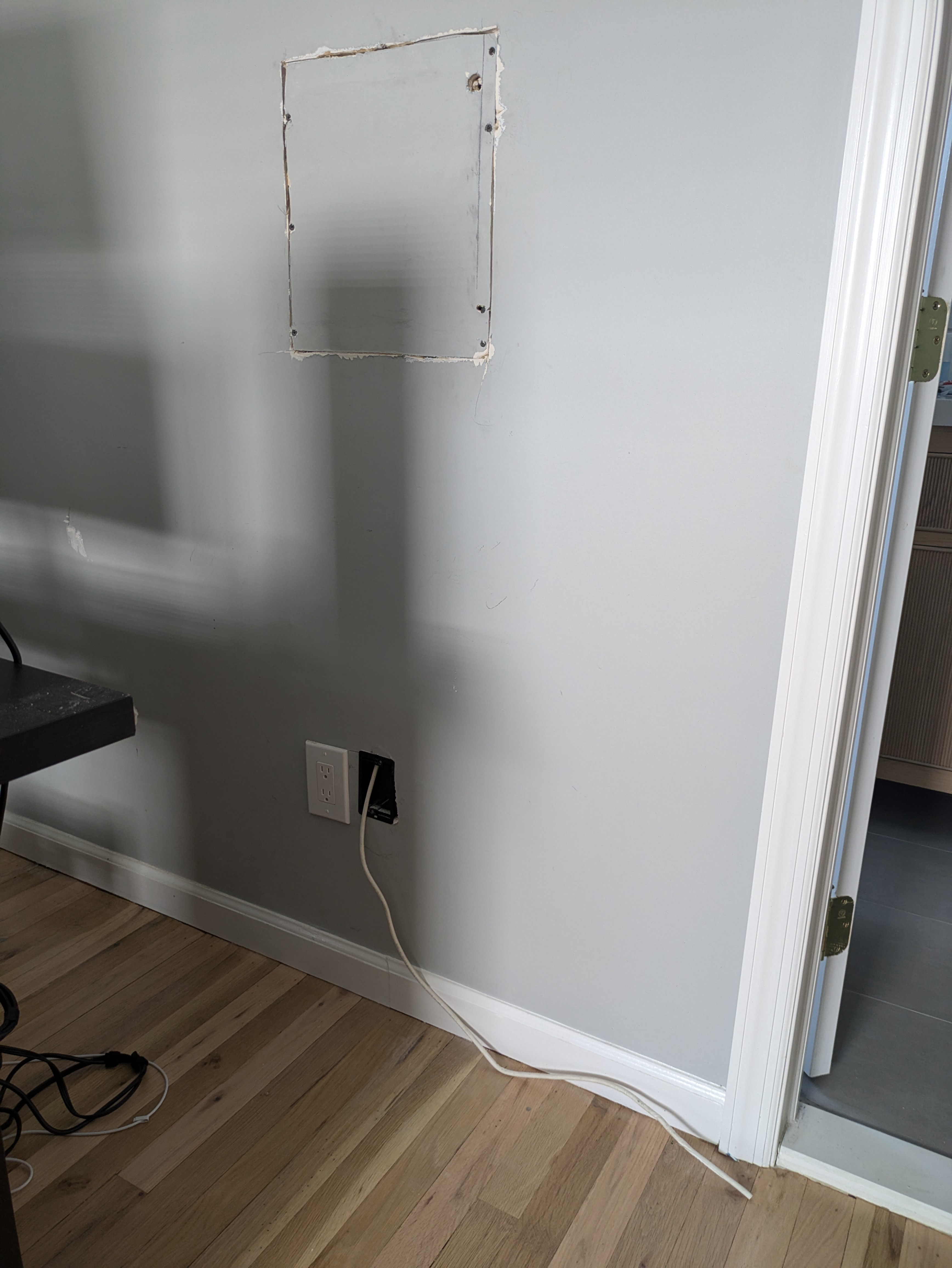 Wall opening prepared for a network panel with an outlet and cable already run