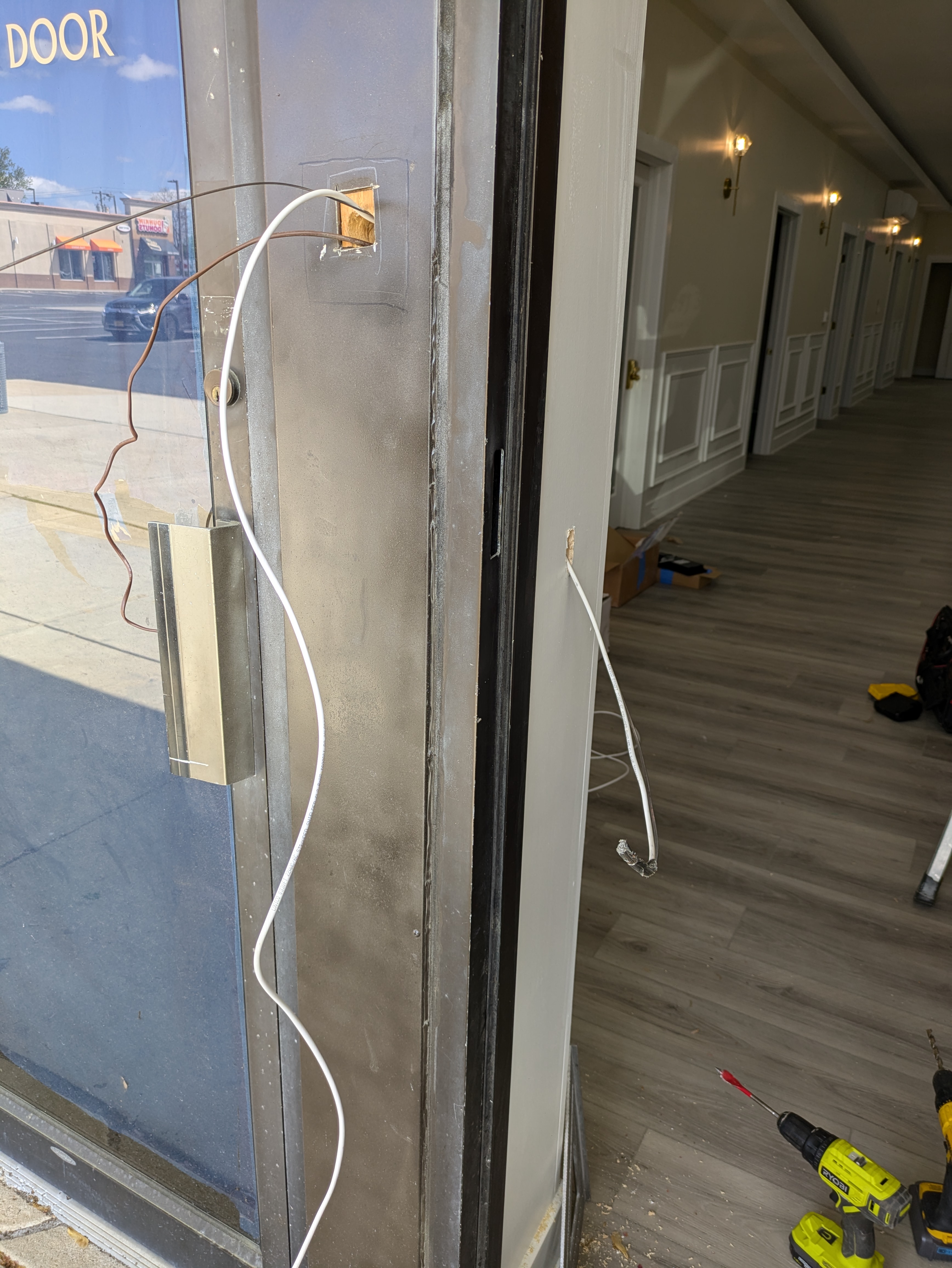 Card reader and magnetic lock wiring installed on a commercial glass entry door