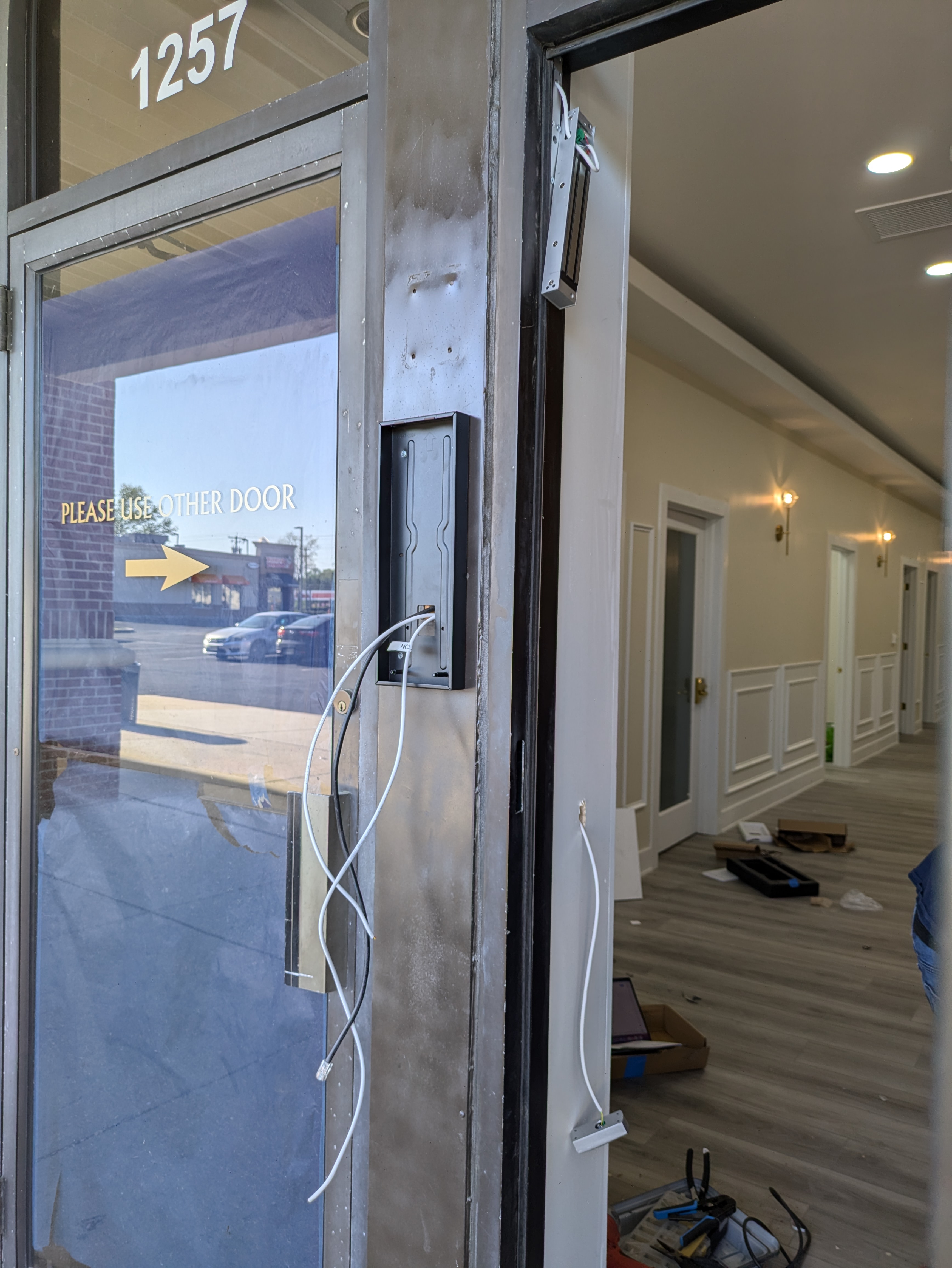 Magnetic door lock and card reader wired above a commercial entryway