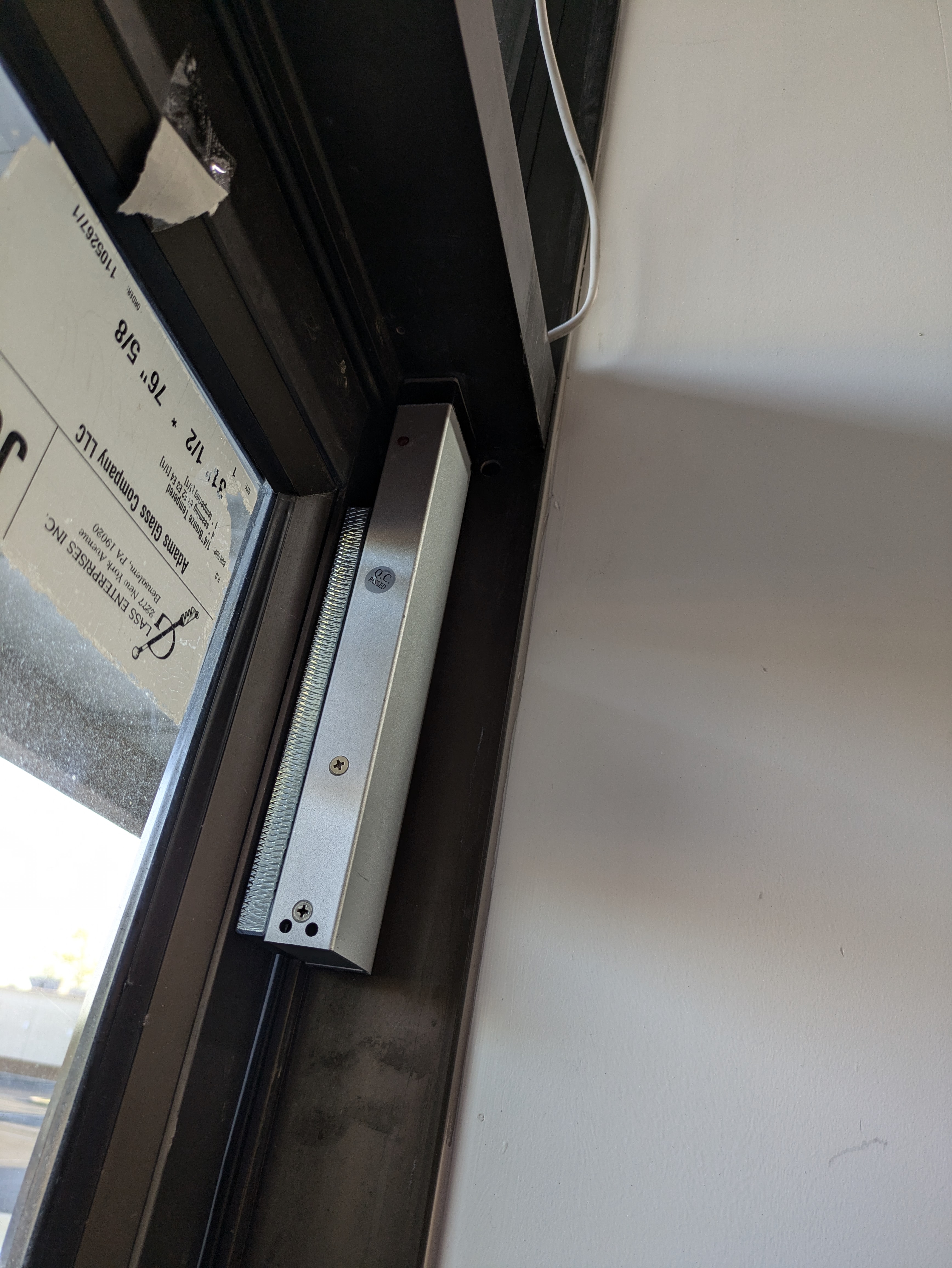 Electric door strike installed in a commercial sliding glass door frame